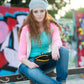 Woman sitting on a ledge with a colorful graffiti background
