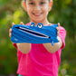 Child holding a blue zipper pouch with a face design against a blurred green background