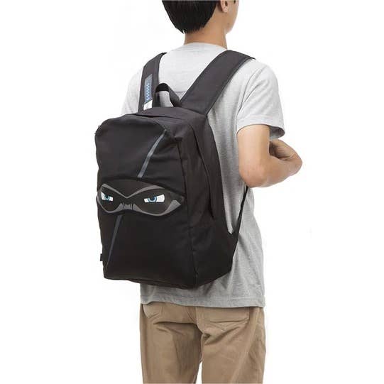 Person wearing a black backpack with a unique design on a white background
